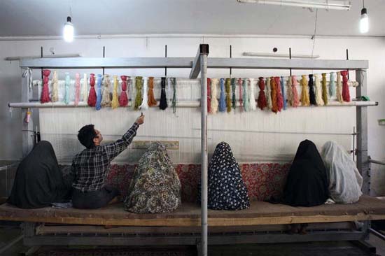 Persian Carpet Weavers in a workshop in Qom. The silk carpets of Qom are known for their high quality. Iran's more than 1 million weavers produce an average of $500 million in exports a year.