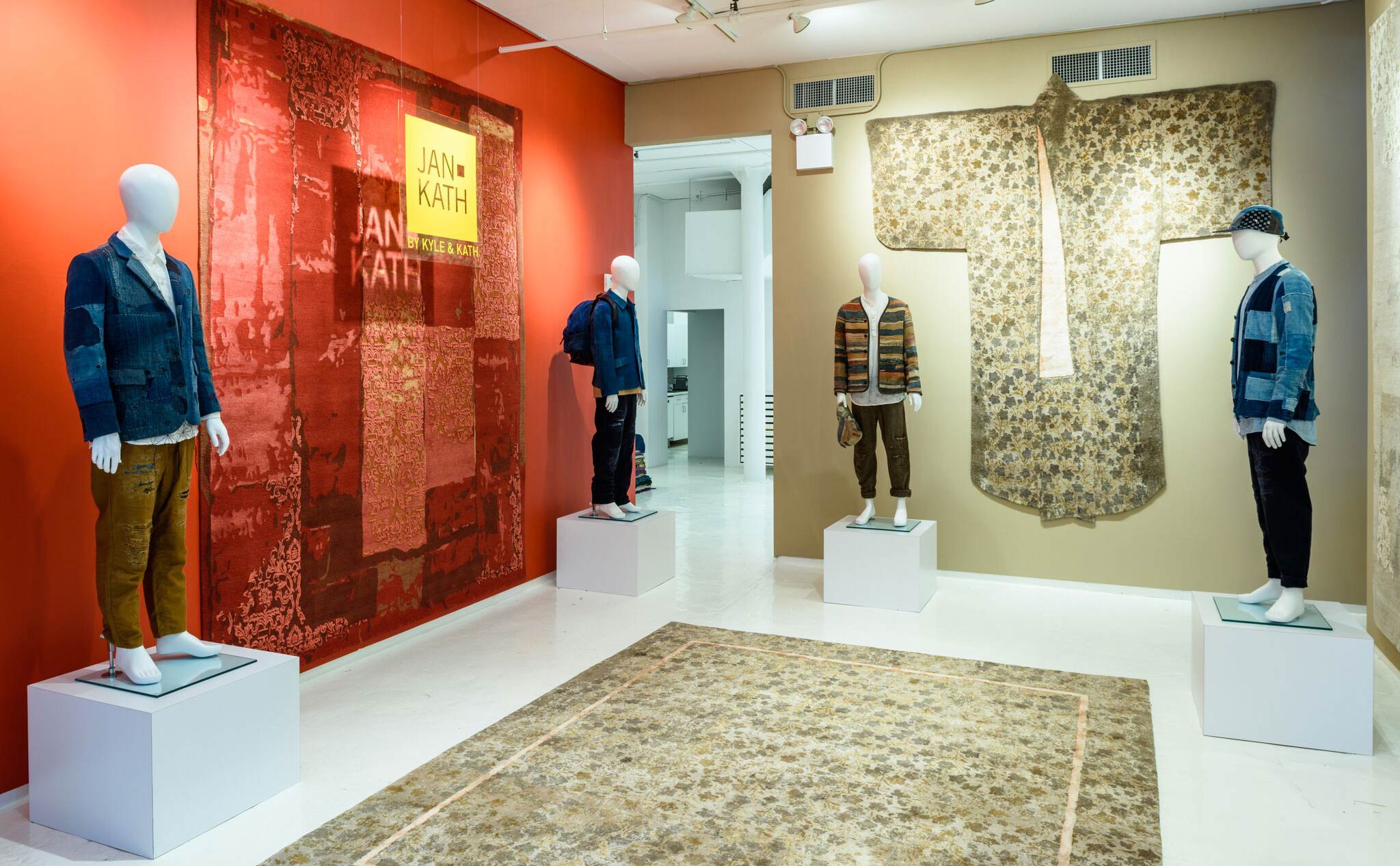 Mannequins dressed in contemporary bespoke Boro clothing from 'Kuon' ask 'What kind of exhibit are we in?' as they stand proud against an assortment of bold Jan Kath carpets including the whimsically shaped 'Dress Carpet' on the far wall. | Image courtesy of Jan Kath.