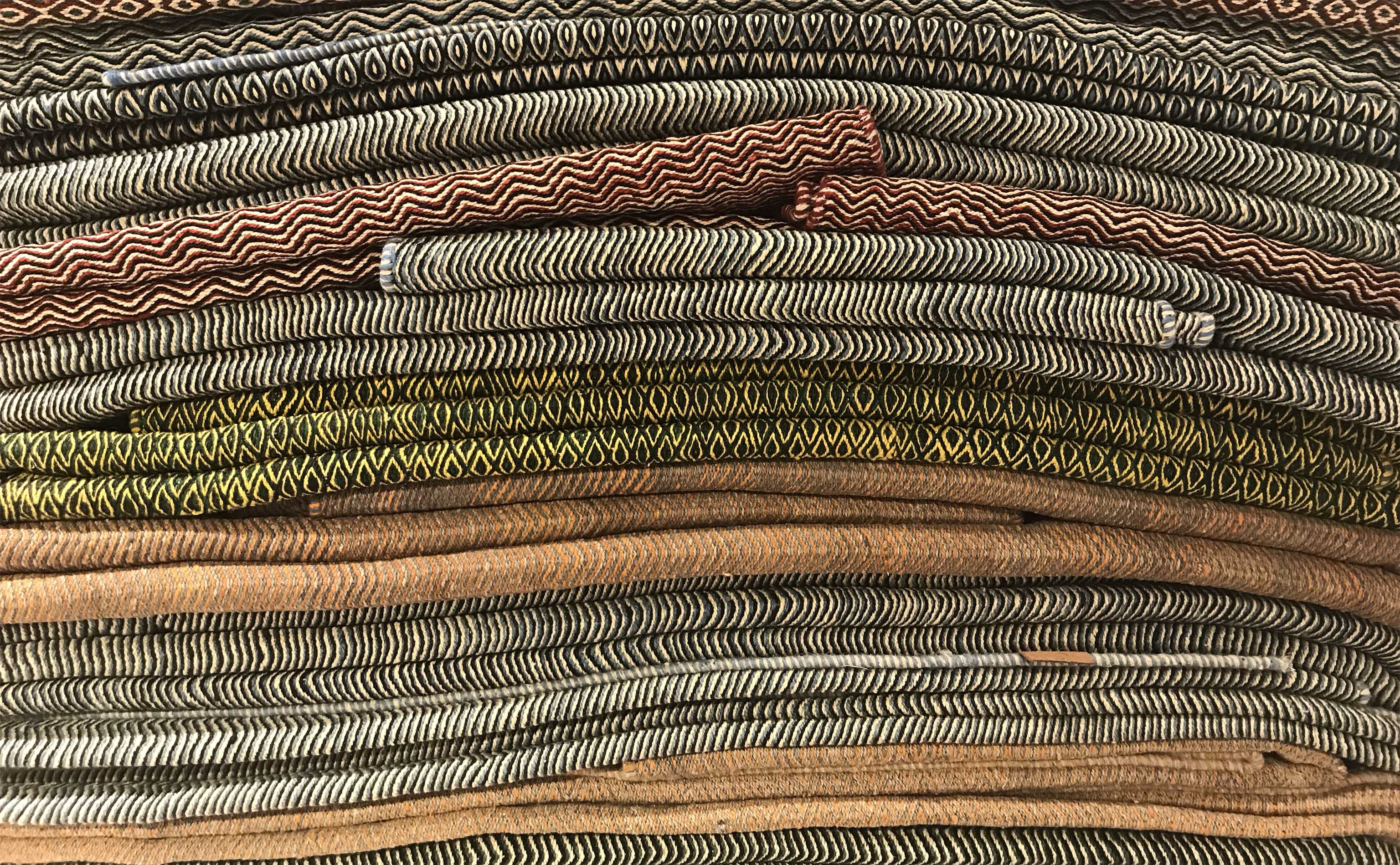 A stack of folded Iranian flatweaves as seen at Edelgrund during Domotex 2019 | Photograph by The Ruggist.