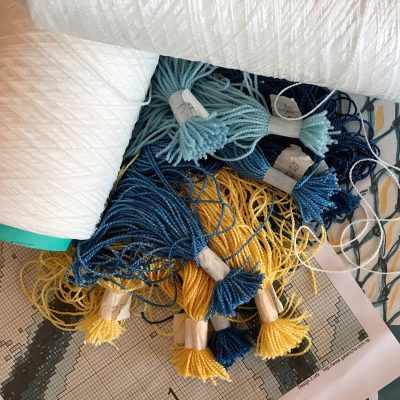 ECONYL® brand regenerated nylon yarn made by Aquafil is being employed by Sarawagi Rugs to make a novel handknotted carpet designed by Isobel Morris. Matte and shiny undyed ECONYL® yarn can be seen here along with dyed colour samples, a portion of the production graph, and just a hint of the final approved design. | Photograph by The Ruggist.